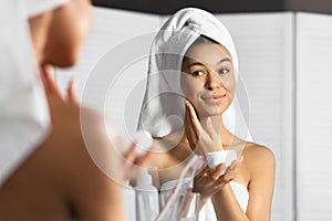 Afro Young Lady Applying Face Cream Standing In Bathroom, Panorama