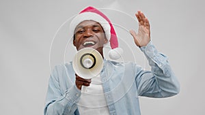 Afroamerican man in red christmas hat shouts loudspeaker on sale, black friday.