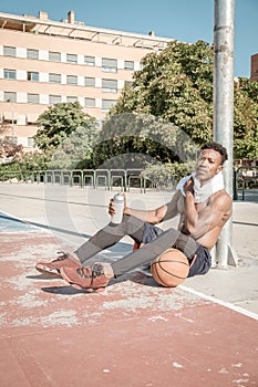 Afroamerican young man playing street basketball in the park