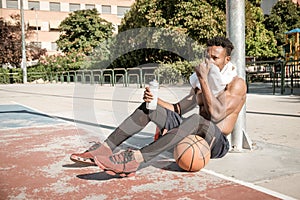 Afroamerican young man playing street basketball in the park