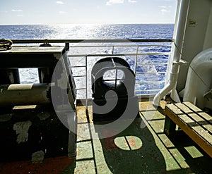 Aft mooring station situated on stern part of container ship behind superstructure. On the green painted main deck are white ropes