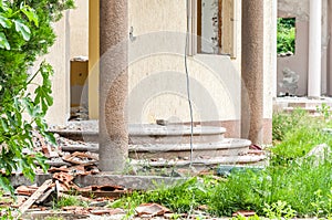 Aftermath damaged and ruined villa in the city from natural disaster, catastrophe or war with broken staircase