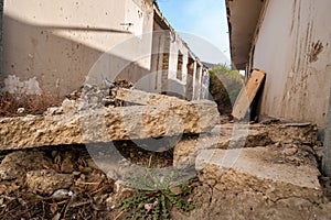 Aftermath remains of hurricane or earthquake disaster damage on ruined old house with collapsed roof and brick walls selective foc