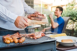 Afternoon Party Group friends enjoying drinking beer with barbecue and roast pork happy while enjoying home party