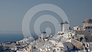Afternoon shot of whitewashed houses and windmills at oia, santorini