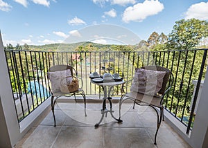 Afternoon tea with dessert and pillow on weave chairs on balcony