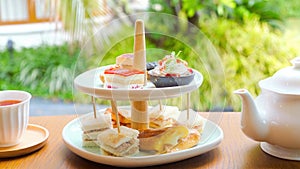 Afternoon tea with fresh cakes, pastries and sandwiches with hot tea