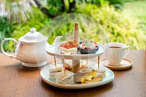 Afternoon tea with fresh cakes, pastries and sandwiches with hot tea