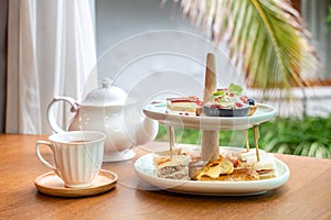 Afternoon tea with fresh cakes, pastries and sandwiches with hot tea