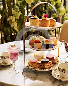 Afternoon tea in the restaurant garden, English tradition and luxury service, tea cups, cakes, scones, sanwiches and desserts,