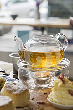 Afternoon tea with teapot and scones on table in a cafe