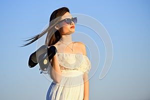 Afterparty concept. Woman sunrise carry high heels in hand. Woman on sunny morning blue sky. Model tender summer dress