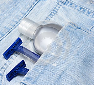 Aftershave lotion and disposable razors in blue jeans pocket