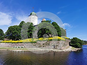 Against the background of a blue sky with feathery clouds, Vyborg Castle and the white Tower of St. Olaf in the city of Vyborg