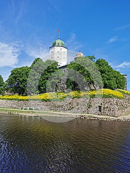 Against the background of a blue sky with feathery clouds, Vyborg Castle and the white Tower of St. Olaf in the city of Vyborg