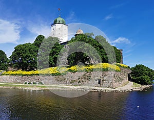 Against the background of a blue sky with feathery clouds, Vyborg Castle and the white Tower of St. Olaf in the city of Vyborg