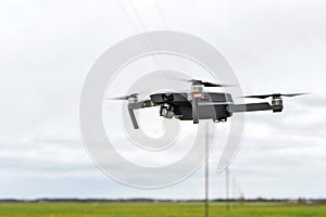 Against the background of a clear sky, a quadrocopter soars in the air