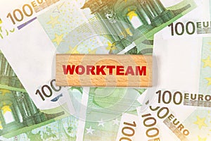 Against the background of euro bills, the text is written on wooden blocks - WORKTEAM