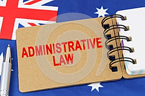 Against the background of the flag of Australia lies a notebook with the inscription - ADMINISTRATIVE LAW