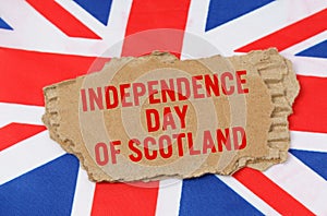 Against the background of the flag of Great Britain lies cardboard with the inscription - Independence Day of Scotland