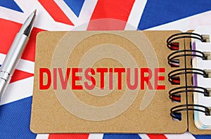 Against the background of the flag of Great Britain lies a notebook with the inscription - DIVESTITURE