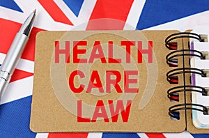 Against the background of the flag of Great Britain lies a notebook with the inscription - HEALTH CARE LAW
