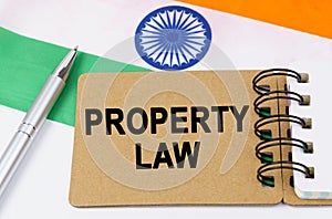 Against the background of the flag of India lies a notebook with the inscription - PROPERTY LAW