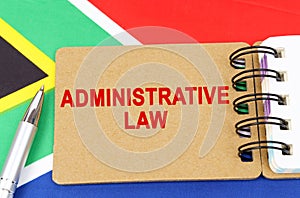 Against the background of the flag of South Africa lies a notebook with the inscription - ADMINISTRATIVE LAW