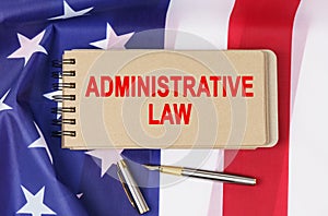 Against the background of the flag of the USA lies a notebook with the inscription - ADMINISTRATIVE LAW