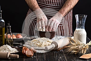 Against the background of men`s hands knead the dough. Ingredients for cooking flour products or dough bread, muffins