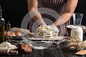 Against the background of men`s hands knead the dough. Ingredients for cooking flour products or dough bread, muffins