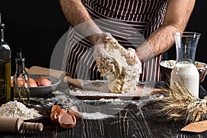 Against the background of men`s hands knead the dough. Ingredients for cooking flour products or dough bread, muffins