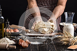 Against the background of men`s hands knead the dough. Ingredients for cooking flour products or dough bread, muffins