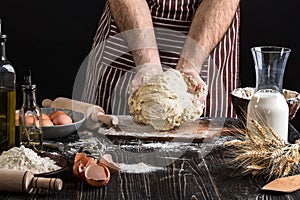 Against the background of men`s hands knead the dough. Ingredients for cooking flour products or dough bread, muffins