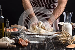 Against the background of men`s hands knead the dough. Ingredients for cooking flour products or dough bread, muffins