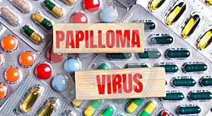 Against the background of multi-colored plates, wooden blocks with the text PAPILLOMA VIRUS. Medical concept