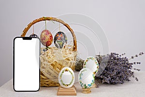 against the background of a shopping cart phone white screen Easter eggs Lavender lavender background postcard baner