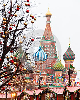 Against the background of St. Basil`s Cathedral, the New Year`s Fair on Red Square, Moscow.