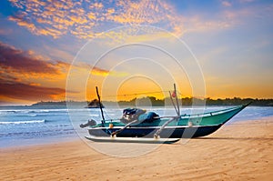 Against the background of the sunset sky and the ocean, an old fishing boat. Sri Lanka