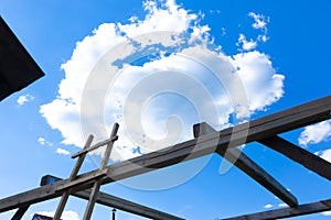Against the background of a timber frame building, a blue sky with white clouds on a bright sunny summer day.