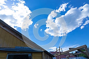 Against the background of a timber frame building, a blue sky with white clouds on a bright sunny summer day.