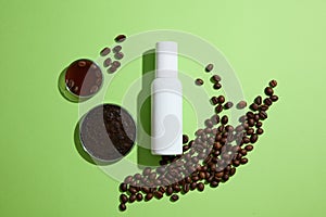 Against a green background, brown coffee beans with white cosmetic bottle and petri dish of coffee grounds decorated. Minimal