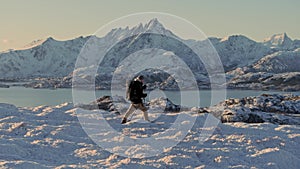 Against a stunning winter backdrop, a hiker bravely treks through the snow, conquering the ascent towards the