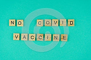 Against vaccination. Lack of vaccine. A crossword puzzle. Words Covid Vaccine stay safe. The phrase is laid out in wooden letters