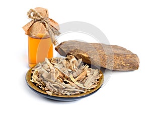 Agarwood, also called aloeswood oudh. With essential oil in pharmaceutical bottle. Isolated on white background