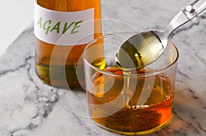 Agave syrup pouring on a glass.