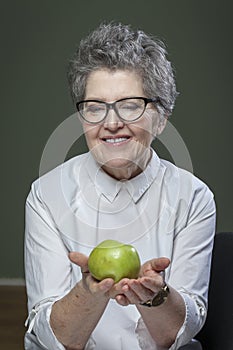 Age, healthy eating, food, diet and people concept - close up of happy smiling senior woman with green apple