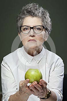 Age, healthy eating, food, diet and people concept - close up of happy smiling senior woman with green apple