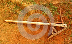 An Aged agricultural plow made from metal and wood.