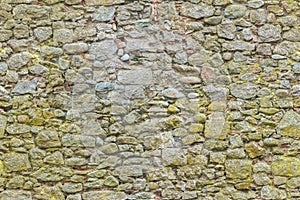 Aged or ancient yellow bricks and stones wall. Seamless brick background